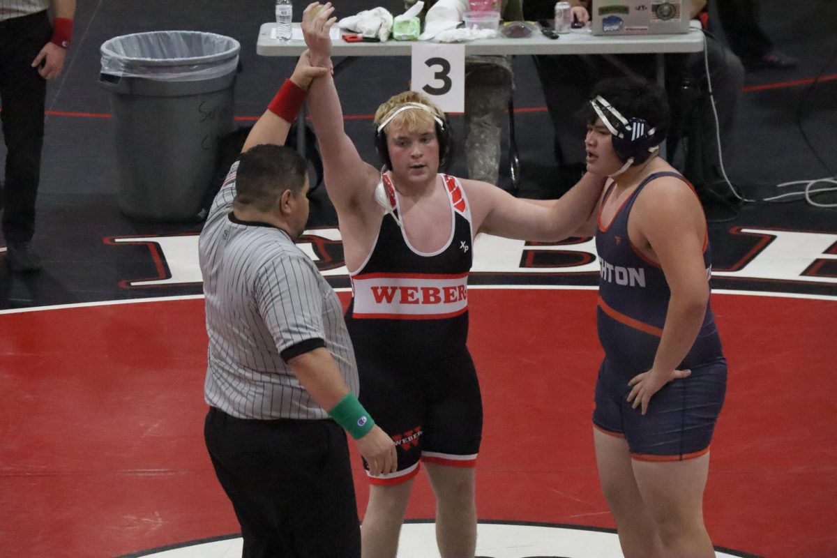 Varsity wrestler and junior Aiden Boden wins his match against a Brighton High School opponent in the big gym at Weber High School on December 12, 2025.